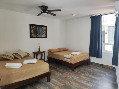 坎昆Villas Carlota Cancún的一间卧室配有两张床和吊扇