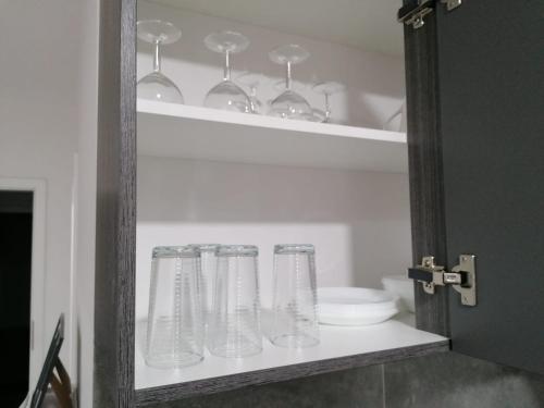 赫恩estrella24 LIVING ROOMS Chita的装满玻璃杯和碗的架子