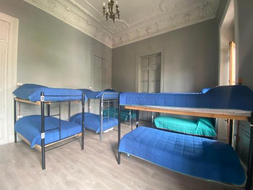 圣地亚哥拉卡莎罗亚旅馆的一间设有蓝色双层床和桌子的房间