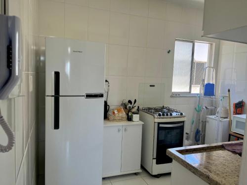 阿拉卡茹Apartamento 3/4 ótima localização的白色的厨房配有冰箱和炉灶。