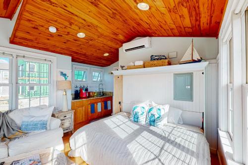 雅茅斯The Atlantic的卧室设有白色的床和木制天花板。