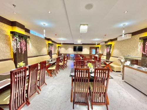普里Hotel AMBIKA PALACE PURI的一间在房间内配有木椅和桌子的餐厅