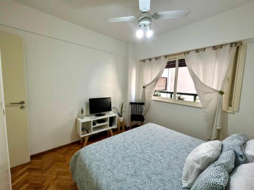 布宜诺斯艾利斯布尔内斯公寓的一间卧室配有一张床、一台电视和一个窗口
