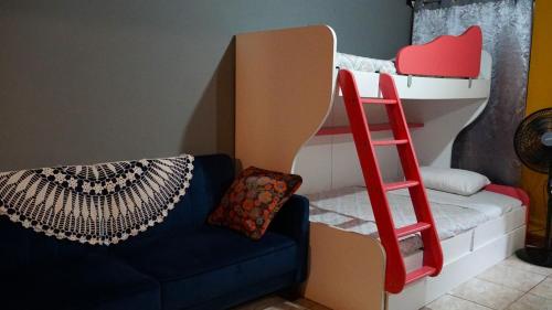 比加瓜TENORIO - Rio Celeste Dreams的一张配有沙发和红色梯子的双层床
