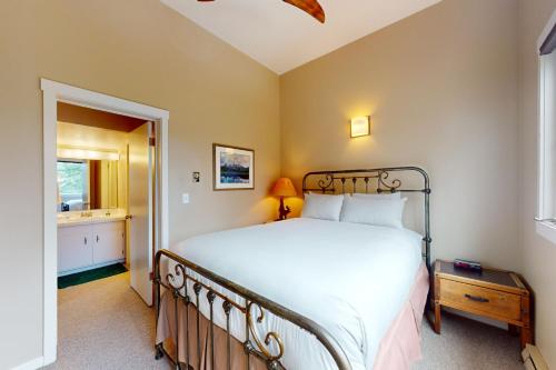 威尔森Moose Creek Lodge的一间带白色大床的卧室和一间浴室