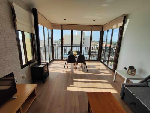 格拉德卡斯特利翁Ático Las Minvas 1ª linea de playa的客厅配有桌椅和窗户。