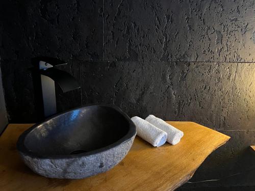 BonsinLoft Zen Essentiel的浴室水槽,木桌上放着碗