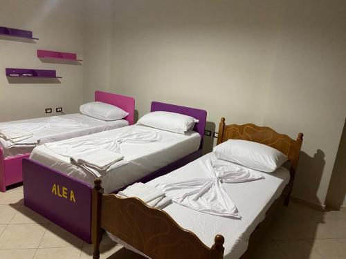 地拉那"Nako" apartment的紫白色客房的两张床
