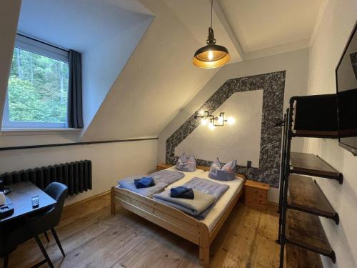 韦尼格罗德Hotel Mühlental的一间卧室配有一张床、一张书桌和一个窗户。