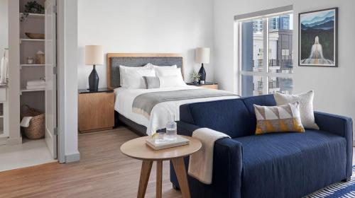 纳什维尔Sentral SoBro的一间卧室配有一张床和一张蓝色的沙发