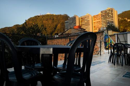 波哥大Hostal Chorro De Quevedo的阳台顶部的桌椅