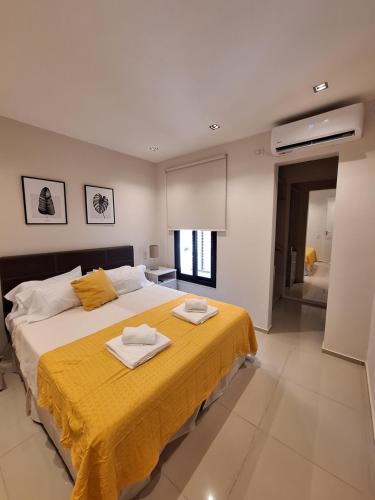 耶尔瓦布埃纳Departamento Premium 2 personas con cochera的一间卧室配有一张大床和两条毛巾