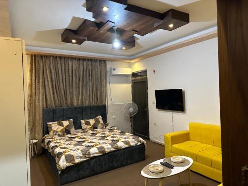 伊尔比德Furnished Studio for rent的一间卧室配有一张床和一张黄色的沙发