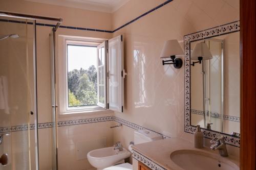 莱里亚玉兰花住宿加早餐旅馆的一间带水槽和卫生间的浴室以及窗户。