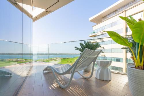 阿布扎比Paradise Holiday Home with Private Beach Access 605B2的阳台配有两把椅子和大窗户