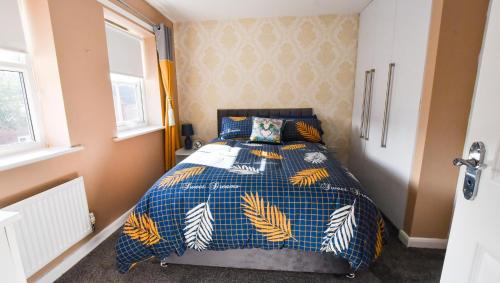利物浦3 Bedroom House close to city centre的一间卧室配有一张蓝色和黄色的被子