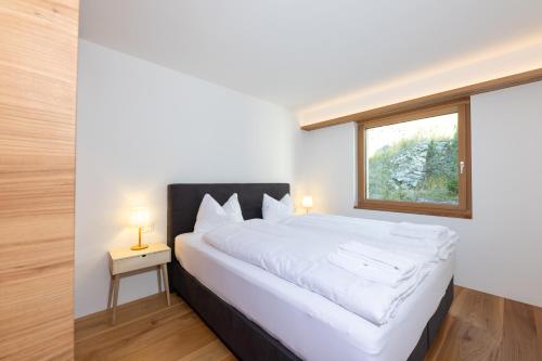 圣莫里茨New! Exclusive Apartment 3min to Chantarella Bahn的卧室配有一张大白色床和窗户
