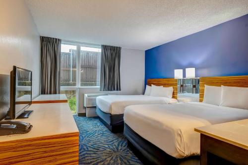 阿林顿Motel 6 Arlington TX Entertainment District的酒店客房设有两张床和电视。