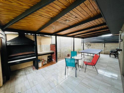 圣地亚哥Casa Aislada Peñaflor-Malloco的天井配有桌椅和钢琴。