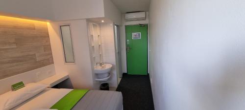 开普敦Check Inn Hotel的一间设有绿色门和卫生间的小浴室
