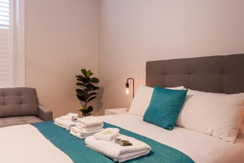 AngastonBarossa Brauhaus Hotel的一间卧室配有带毛巾和椅子的床