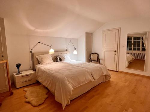 VésenazLe Cottage的卧室设有一张白色大床和木地板