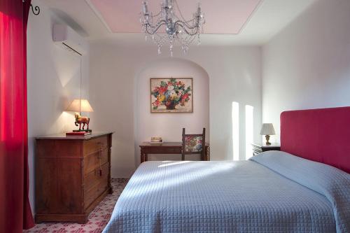 伊斯基亚Villa Gianturco - Luxury In The Green Island的一间卧室配有一张床、梳妆台和吊灯。