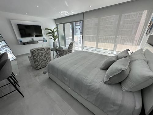 圣胡安Ocean Front Coral Luxury Apartment的一间卧室配有一张大床和电视