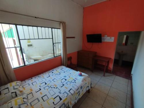 普卡尔帕LAS ORQUIDEAS Hospedaje的一间卧室设有床、窗户和水槽
