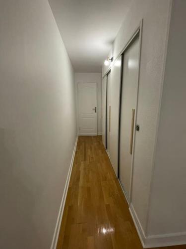 圣吉欧梅斯Super appartement à vitry-sur-seine的走廊设有白色墙壁和木地板