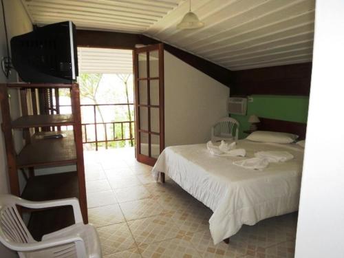 乌巴图巴Casarão Villa al Mare的一间卧室配有一张床和一台电视