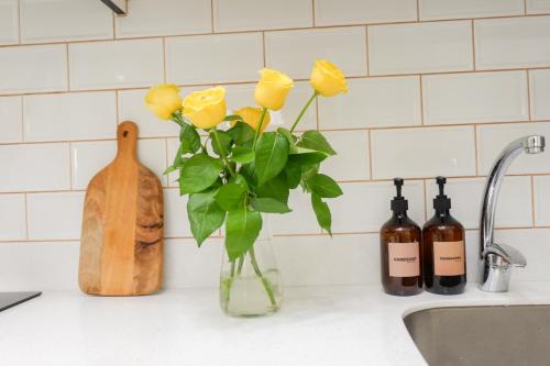 马尼拉Queen Suite with City View at Acqua Private Residences的厨房柜台上有一个黄色玫瑰花花瓶