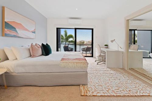 黄金海岸Escape to Clear Island - A Palmy Waterfront Oasis的一间卧室配有一张床和一张书桌,另一间享有美景。