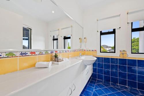黄金海岸Escape to Clear Island - A Palmy Waterfront Oasis的浴室设有白色水槽和蓝色瓷砖