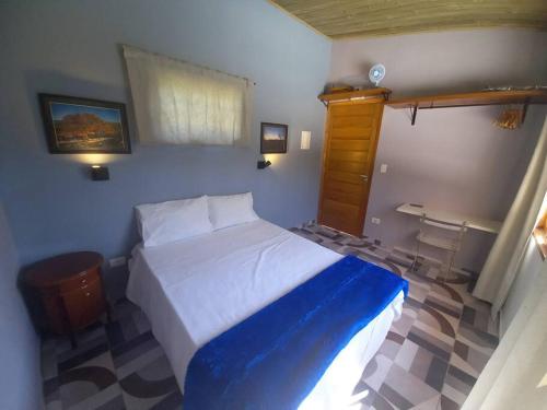 圣罗克Casinha acolhedora da mata - Rota do Vinho的一间卧室配有一张带蓝白色毯子的床