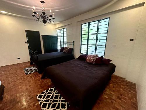 卡兰巴G-HOTEL LUXURY VILLA RESORT AND HOT SPRING的一间卧室配有一张大床和一个吊灯。