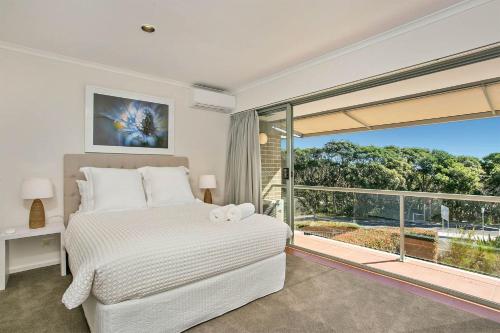 拜伦湾A Perfect Stay - 2 James Cook Apartments的一间卧室设有一张床和一个大窗户