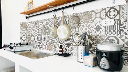 邦劳Panglao Lofts的厨房设有水槽和瓷砖墙