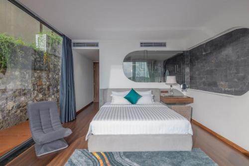 芽庄Ocean Front Villa Nha Trang的一间卧室配有一张大床和一把椅子