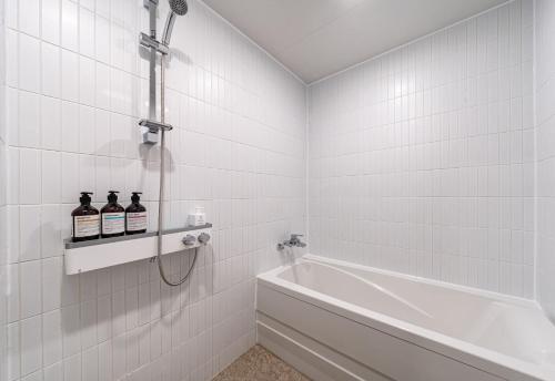 丽水市Browndot Hotel Yeosu Yeocheon的白色的浴室设有浴缸和水槽。