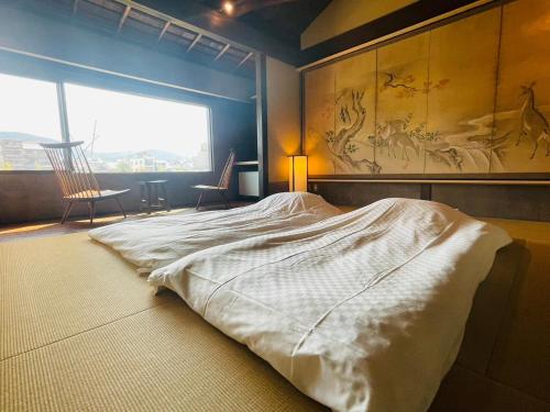 Giommachi京都　水凪庵　Kyoto Mizunagian的一间卧室设有一张大床和大窗户