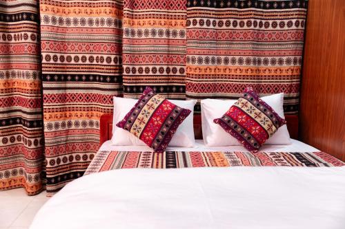河江AmberSun Travel & Tours的一间卧室配有带枕头的床