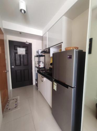 宿务Studio Condotel Unit in Cebu City #NetflixandChill的厨房配有冰箱和黑色门