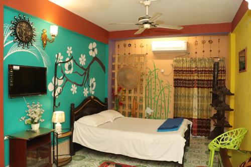 斯里曼加尔乌帕齐拉Green Leaf Guest House ColIege Road Sreemongal的一间卧室配有一张床和一台电视。