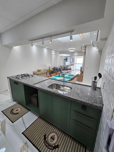 大普拉亚Lamore的一个带绿色台面的厨房和一间客厅
