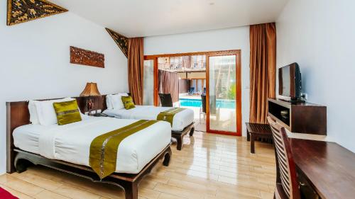 瑶亚岛Blue Bay Resort - Near Phuket & Krabi的酒店客房设有两张床和电视。