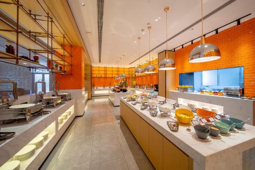 花都广州白云国际机场可可酒店的大厨房设有长台面,上面有碗