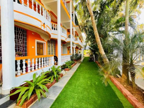 阿姆波尔Samantha Inn Beach Resort的棕榈树和草地的建筑的庭院