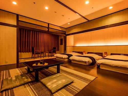 芦原市Yukai Resort Premium Seiunkaku的酒店客房设有两张床和一张桌子。