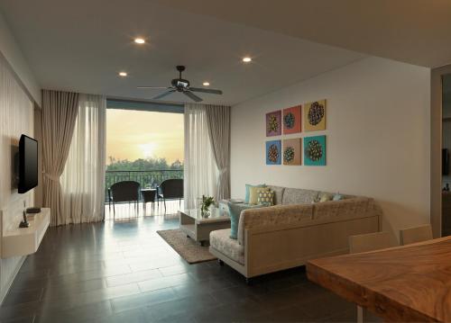 迈考海滩Avani Plus Mai Khao Phuket Suites的带沙发和电视的客厅
